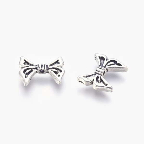 Antikolt ezüst színű masni köztes (12x14mm)